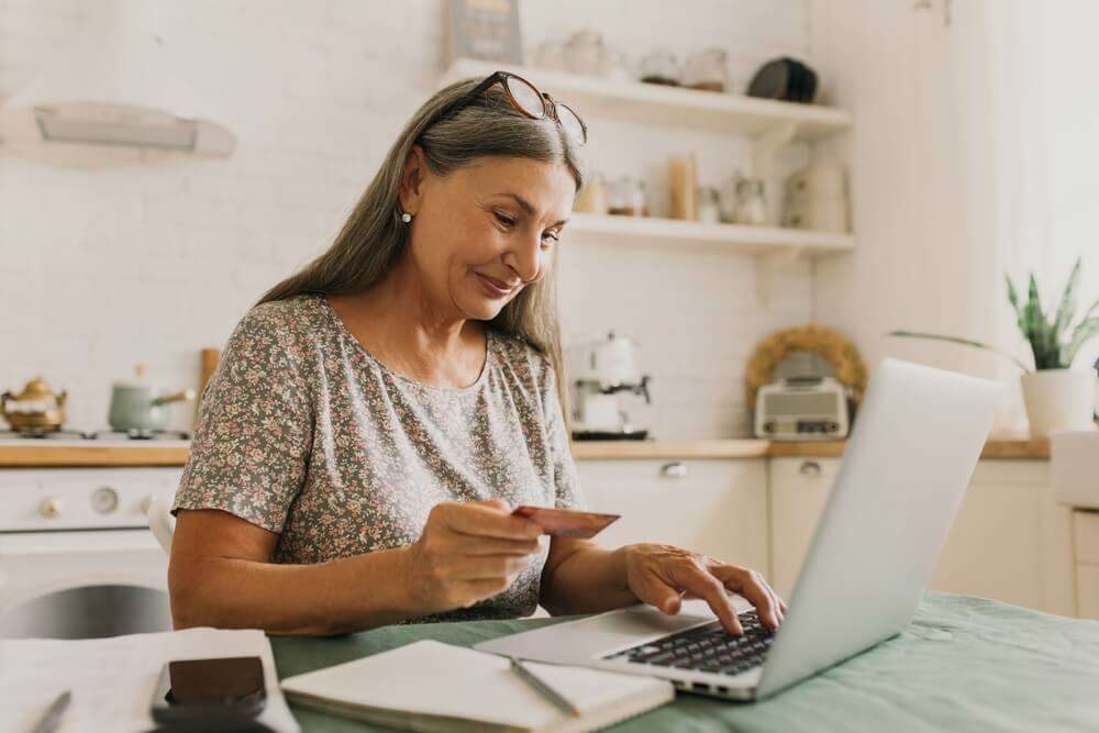 Woman on laptop with bank card